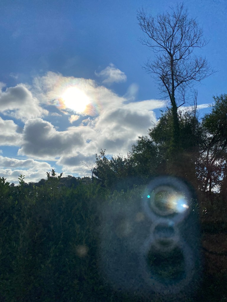 Early morning sunshine through the clouds, with camera refection.