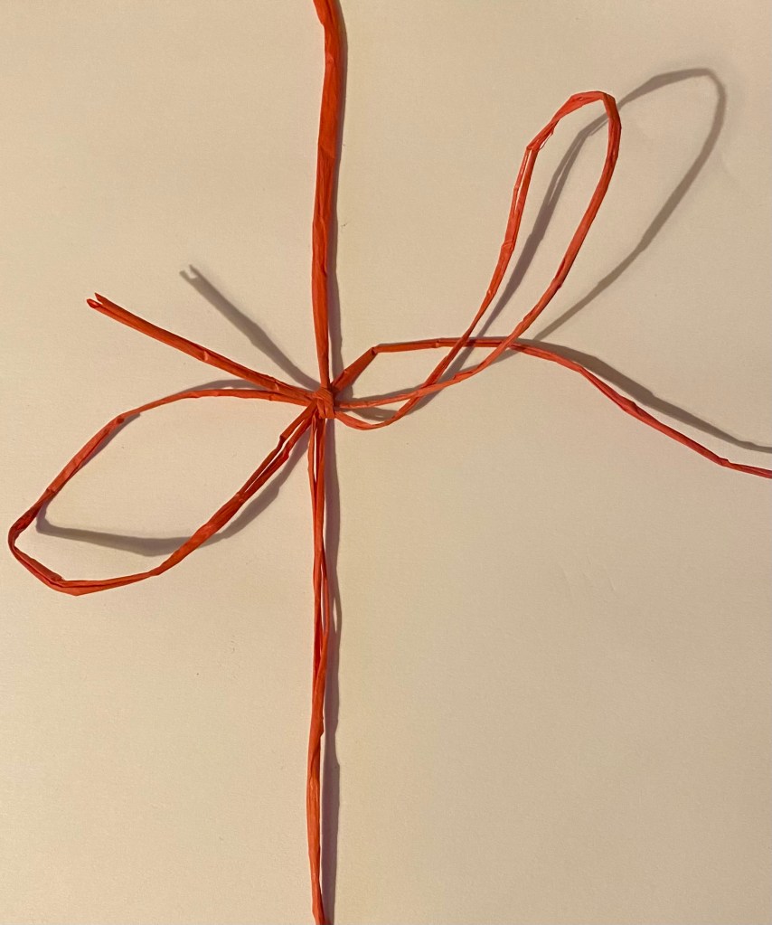 Red string tied in a bow.