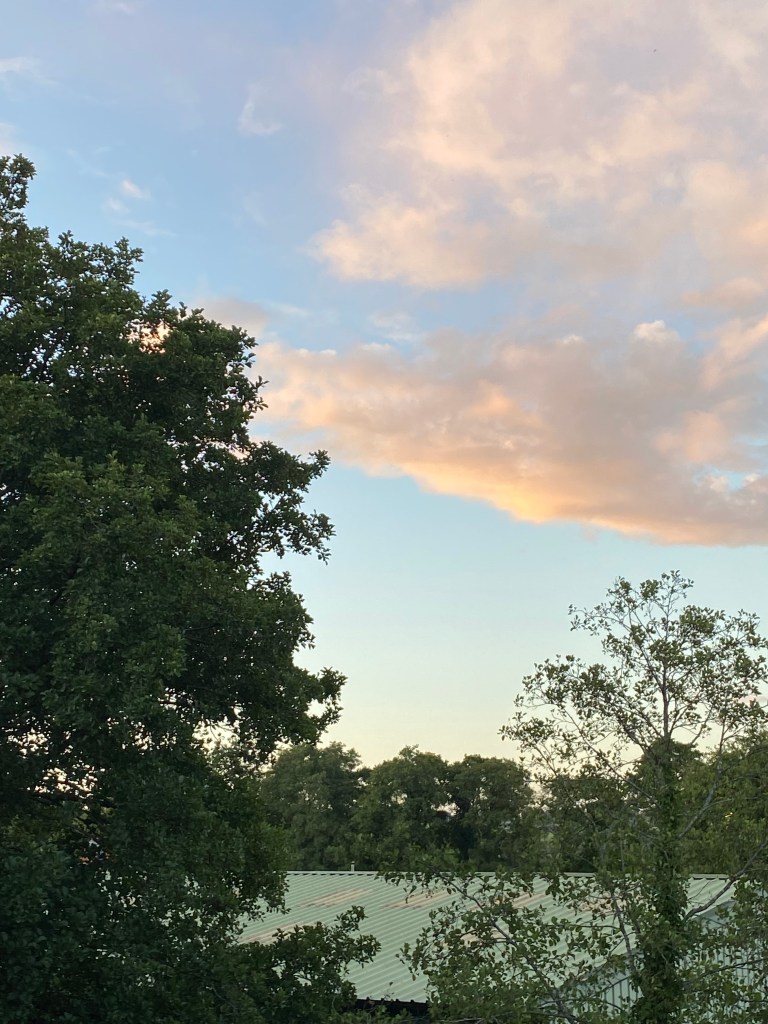 Colourful clouds over a green roof.