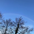 Faint rainbow in a blue sky.