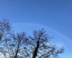 Faint rainbow in a blue sky.